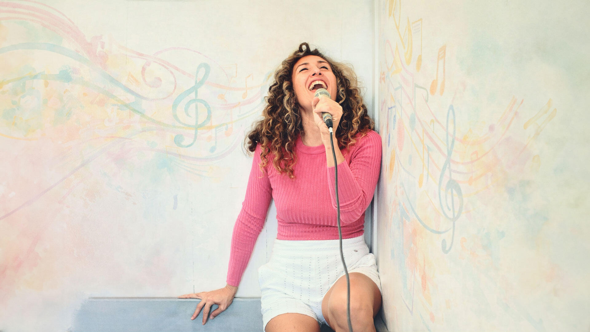 con microfono mentre canta in ambiente creativo con note musicali disegnate